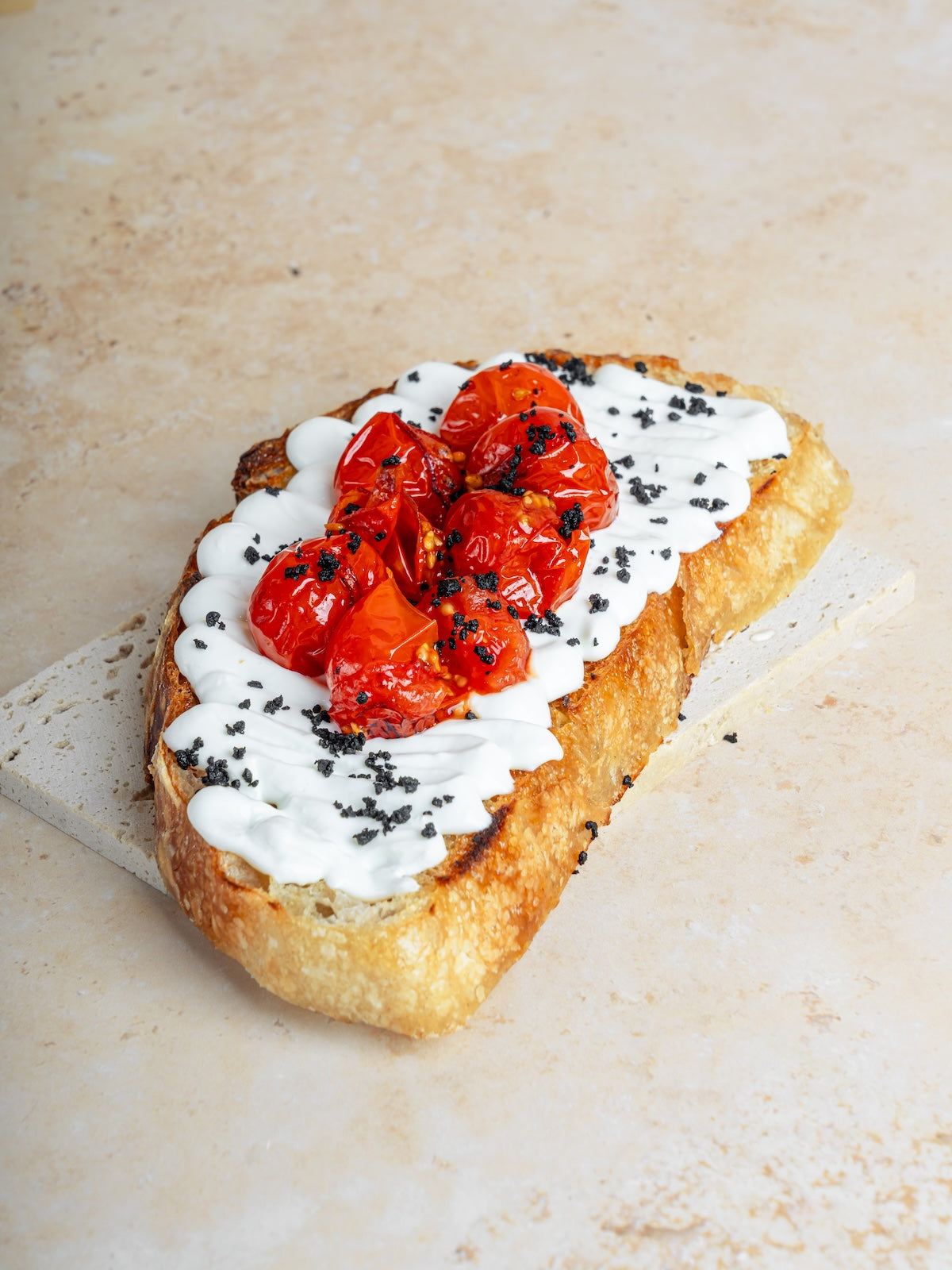 Whipped feta & roasted tomatoes toast w/ garlic, & olive crumble