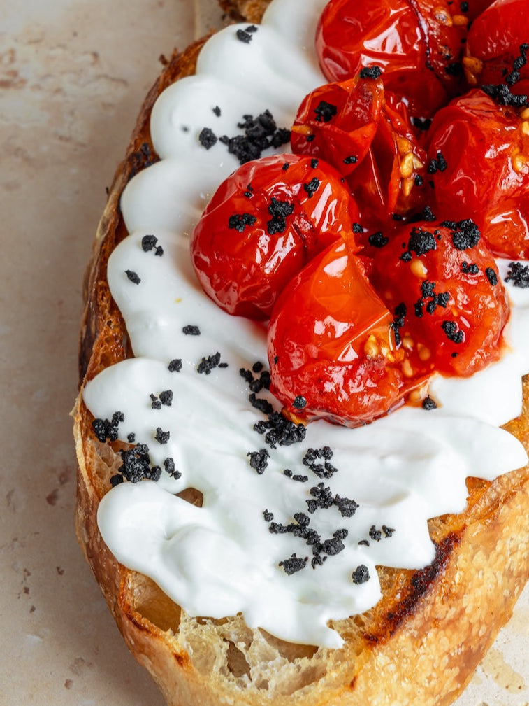 Whipped feta & roasted tomatoes toast w/ garlic, & olive crumble