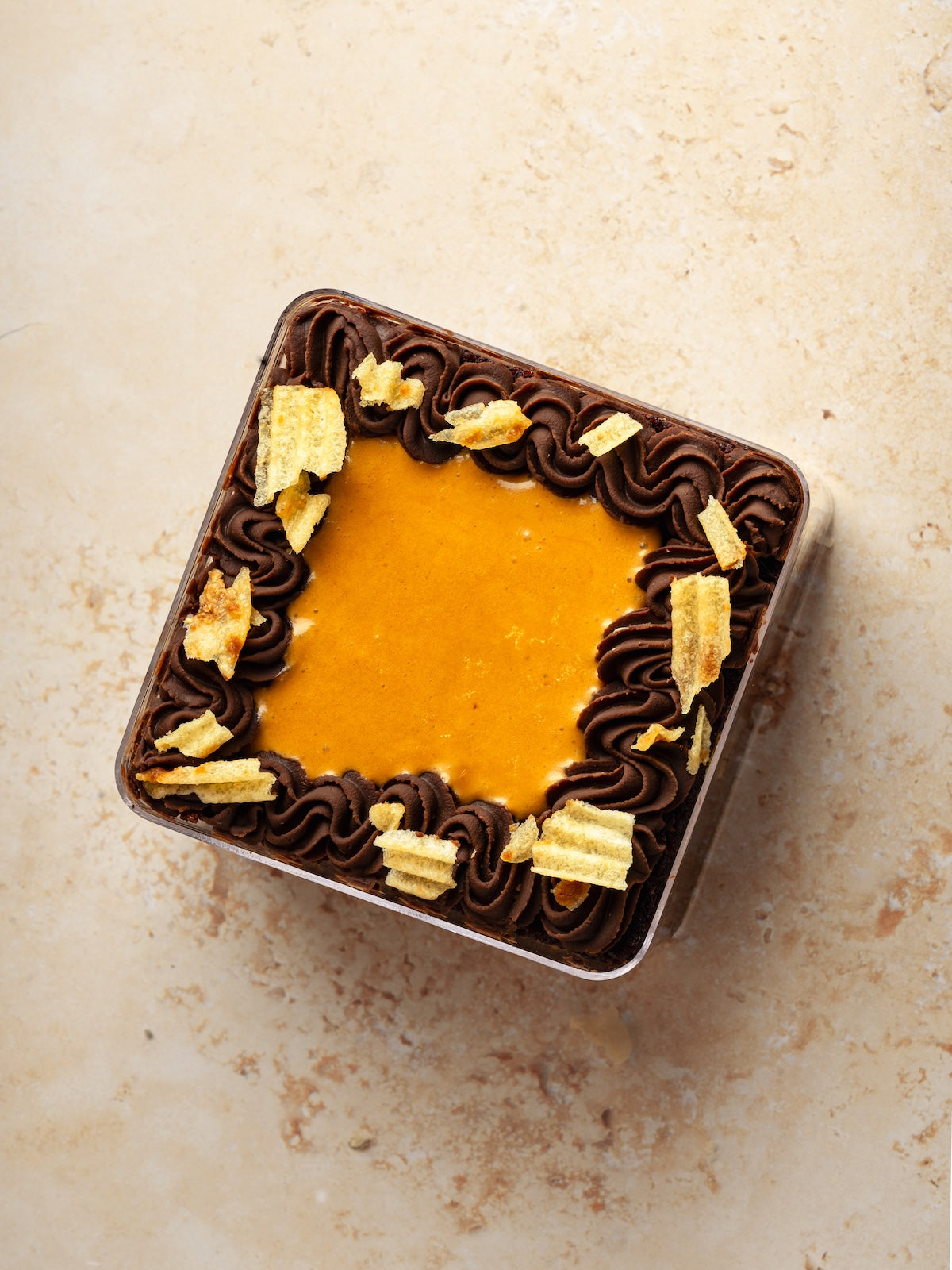 Chocolate cake with whipped caramel, caramelized potato chips & fudge frosting